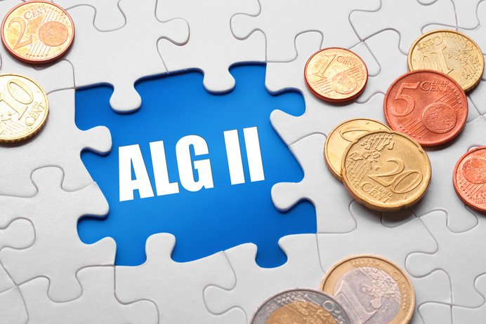 Wort ALG II im fehlenden Puzzleteil, umgeben von Euro- und Centmünzen